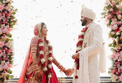 Couple smiling under falling rose petals