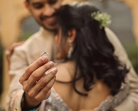 Wedding couple dancing under flowers with confetti